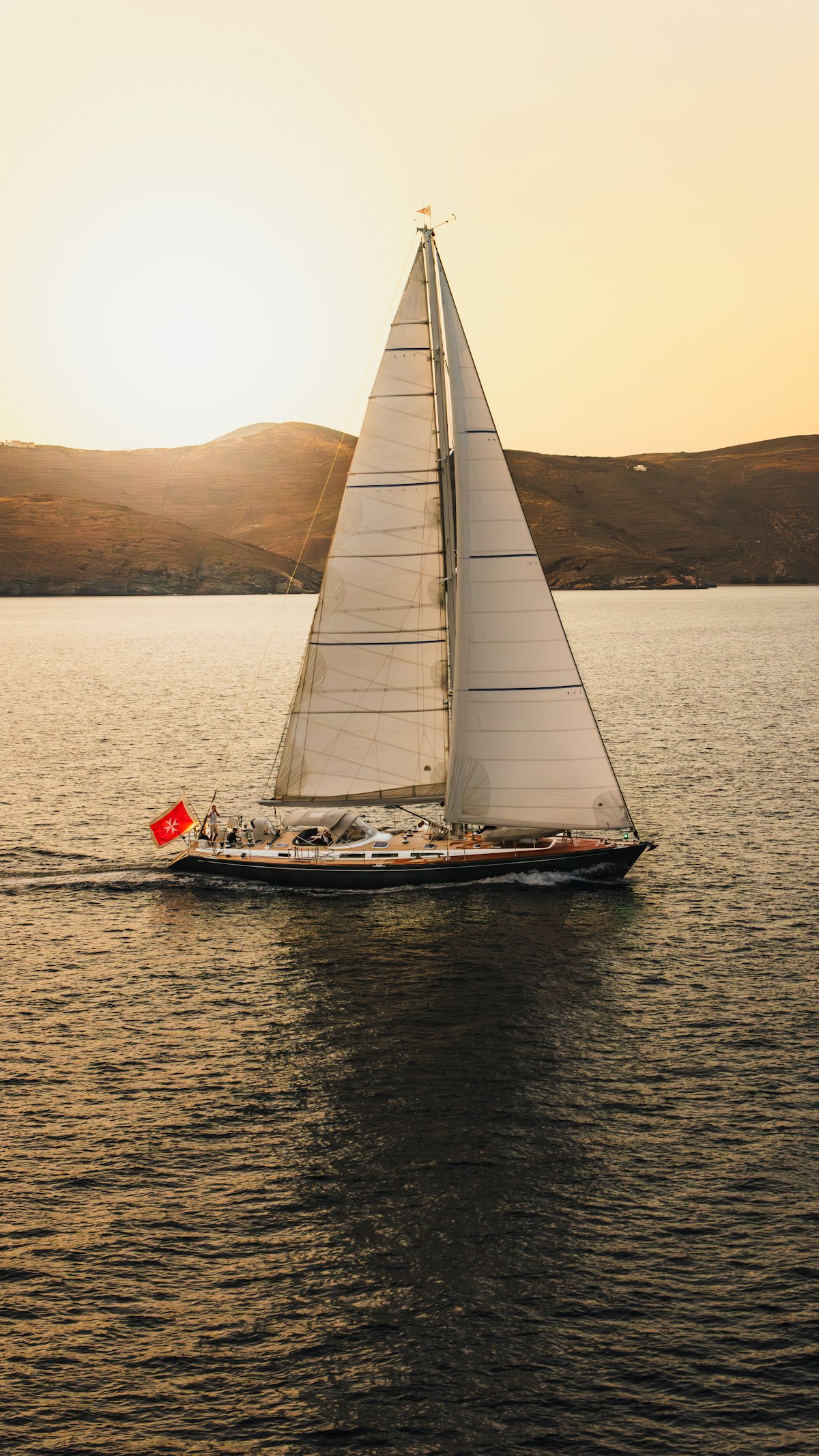 Velero navegando al atardecer, imagen ilustrativa